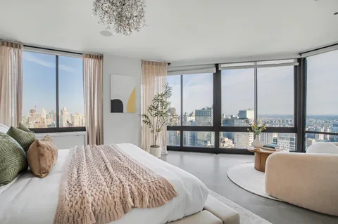 a living room with furniture and a floor to ceiling window