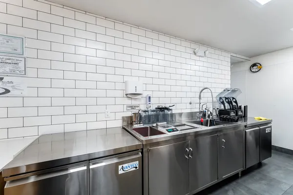 a large kitchen with stainless steel appliances lots of counter space and a sink