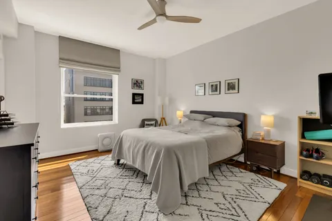 a bedroom with a bed and a flat tv screen on dresser