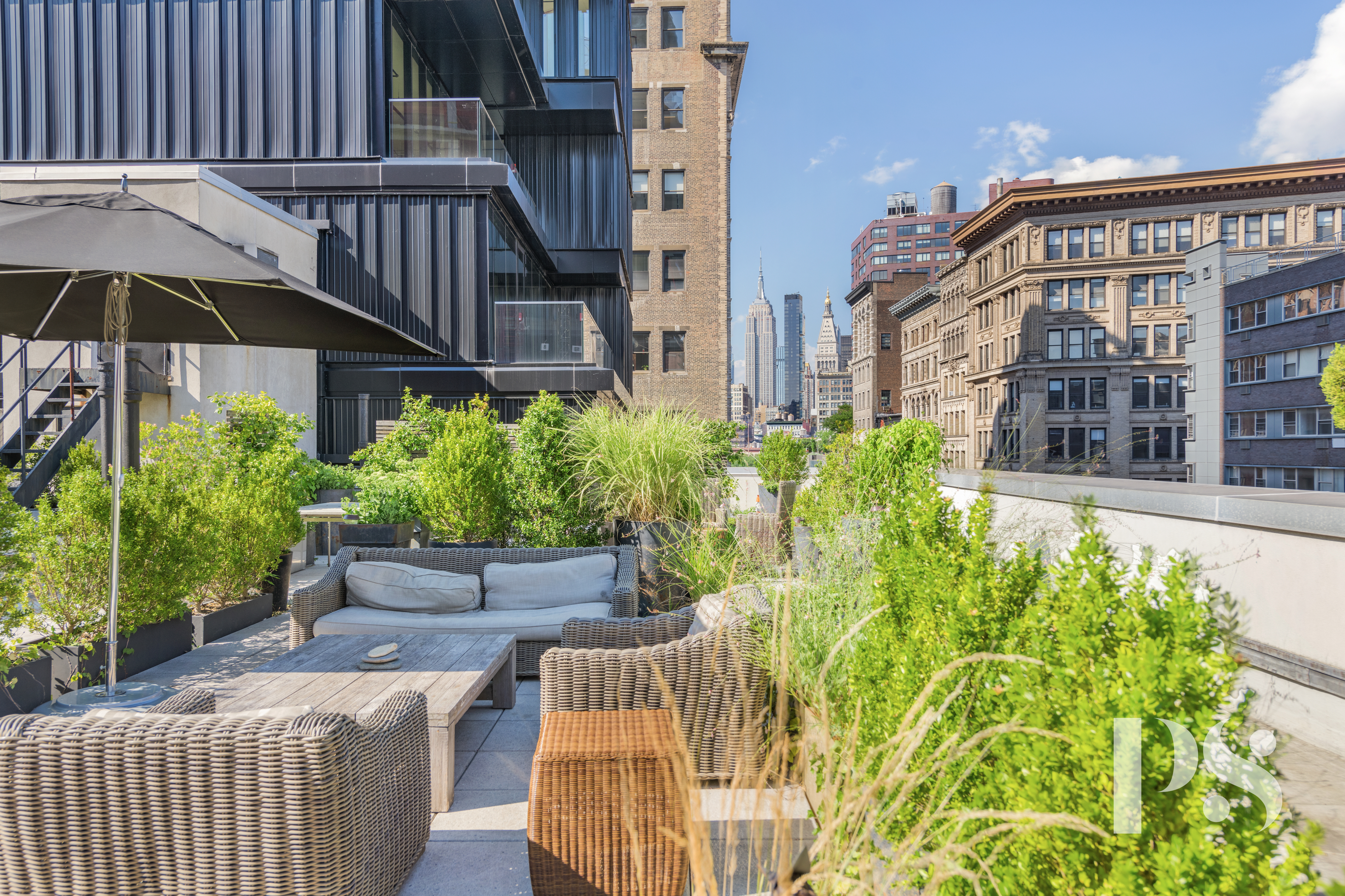 67 East 11th Street, Unit 517 Manhattan, NY 10003 - Photo 12 of 13 a view of a patio with couches table and chairs under an umbrella