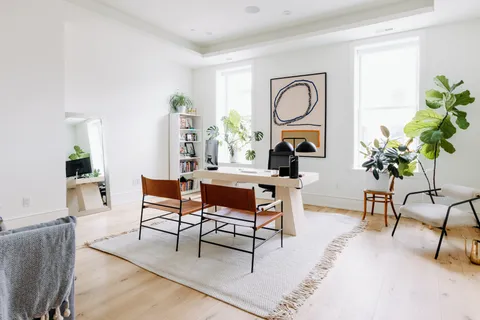 a living room with furniture a rug and a potted plant