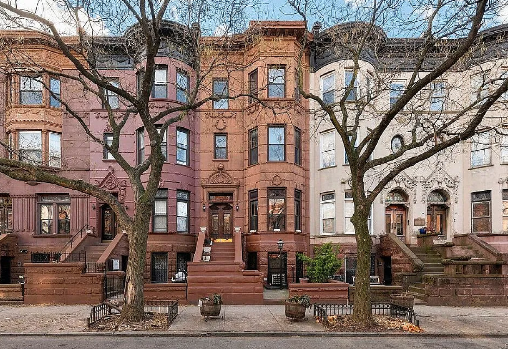 a front view of a building with large trees