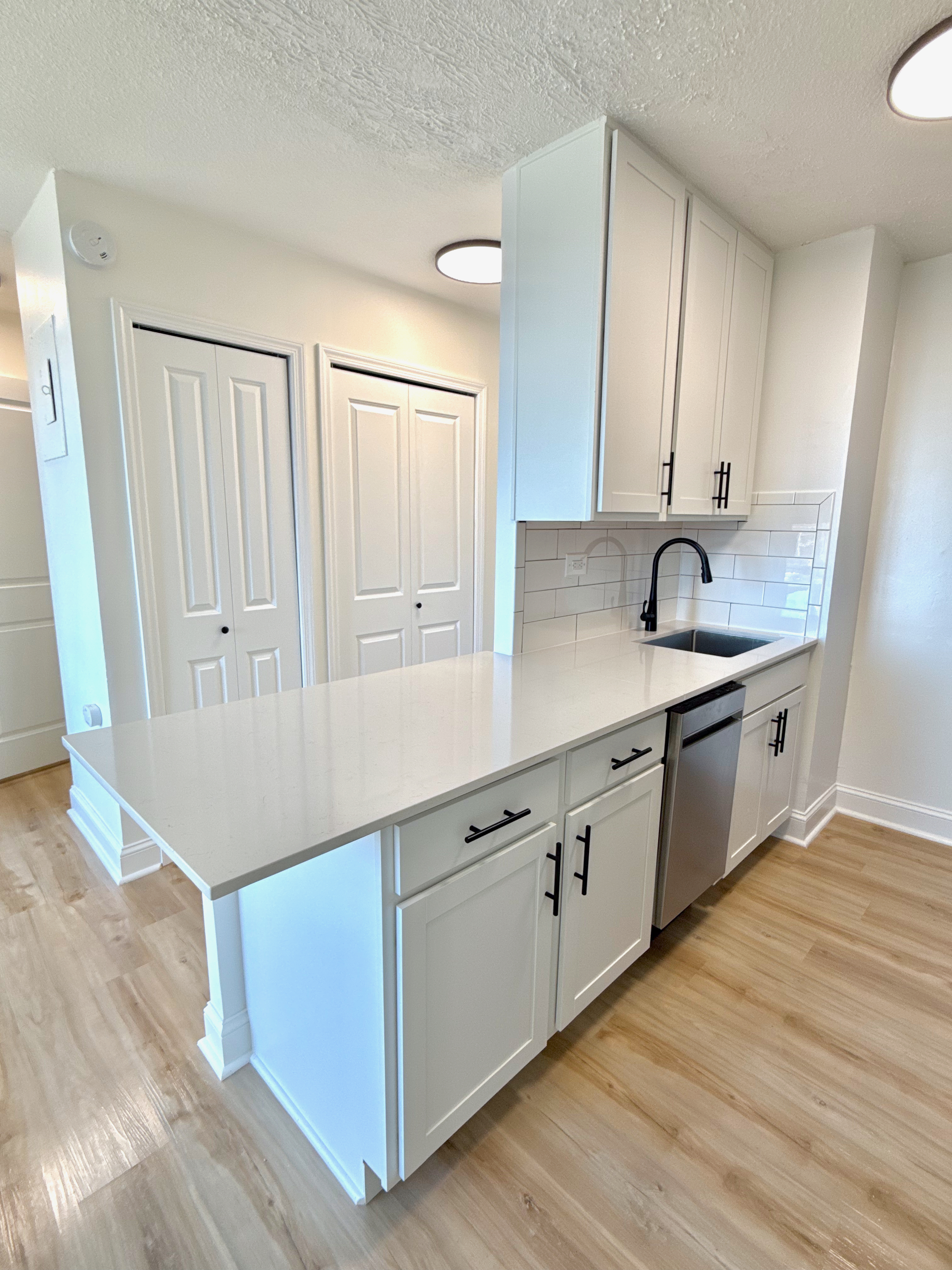 3333 Broadway, Unit D8J Manhattan, NY 10031 - Photo 2 of 22 a kitchen with granite countertop white cabinets and white appliances
