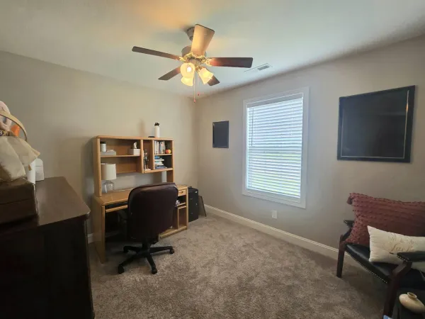 a view of a workspace with furniture and a window
