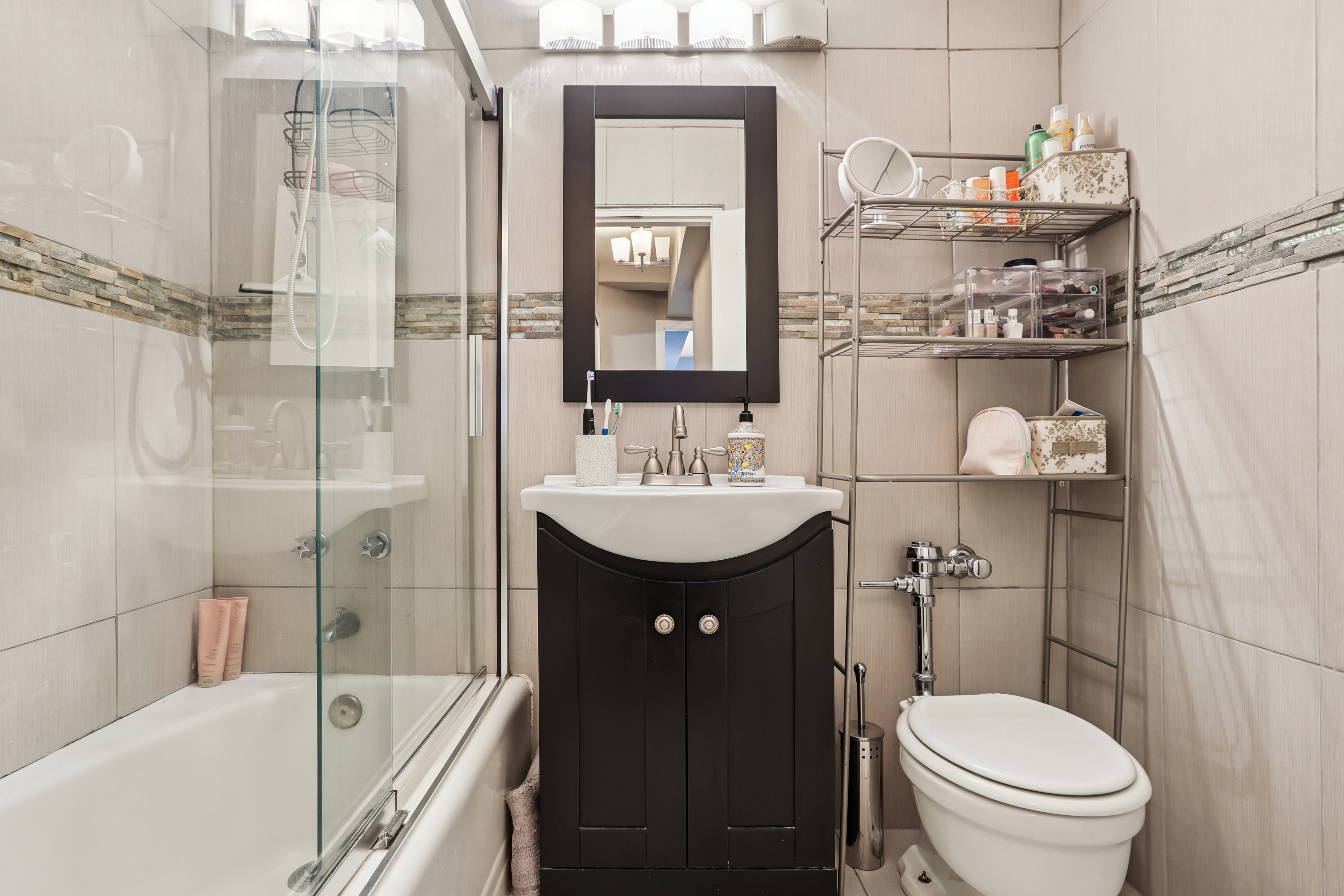 335 East 51st Street, Unit 4H Manhattan, NY 10022 - Photo 8 of 13 a bathroom with a sink a toilet and shower