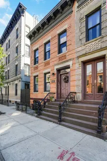 a front view of a house with a bench