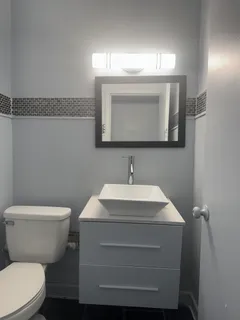 a bathroom with a toilet sink and mirror