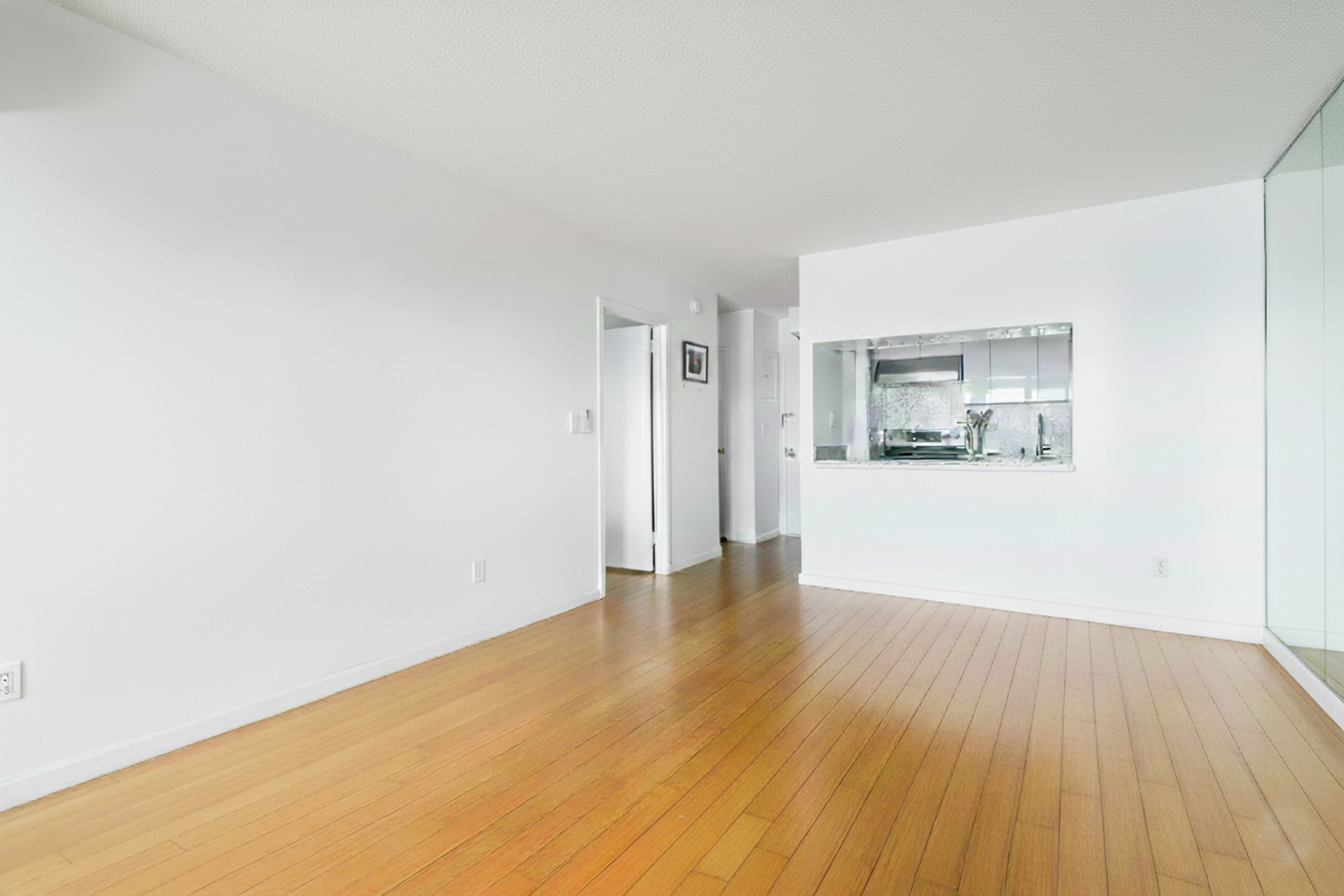 2540 Shore Boulevard, Unit 4S Queens, NY 11102 - Photo 8 of 31 a view of a big room with wooden floor and windows