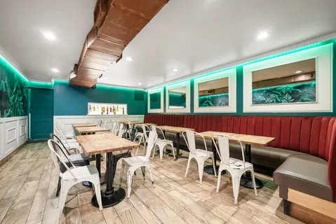 a view of a dining room with furniture a rug and wooden floor