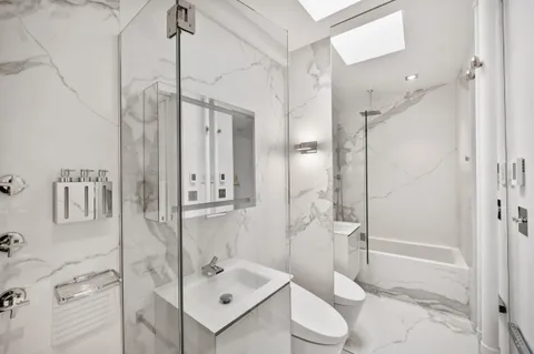 a bathroom with a shower sink and toilet