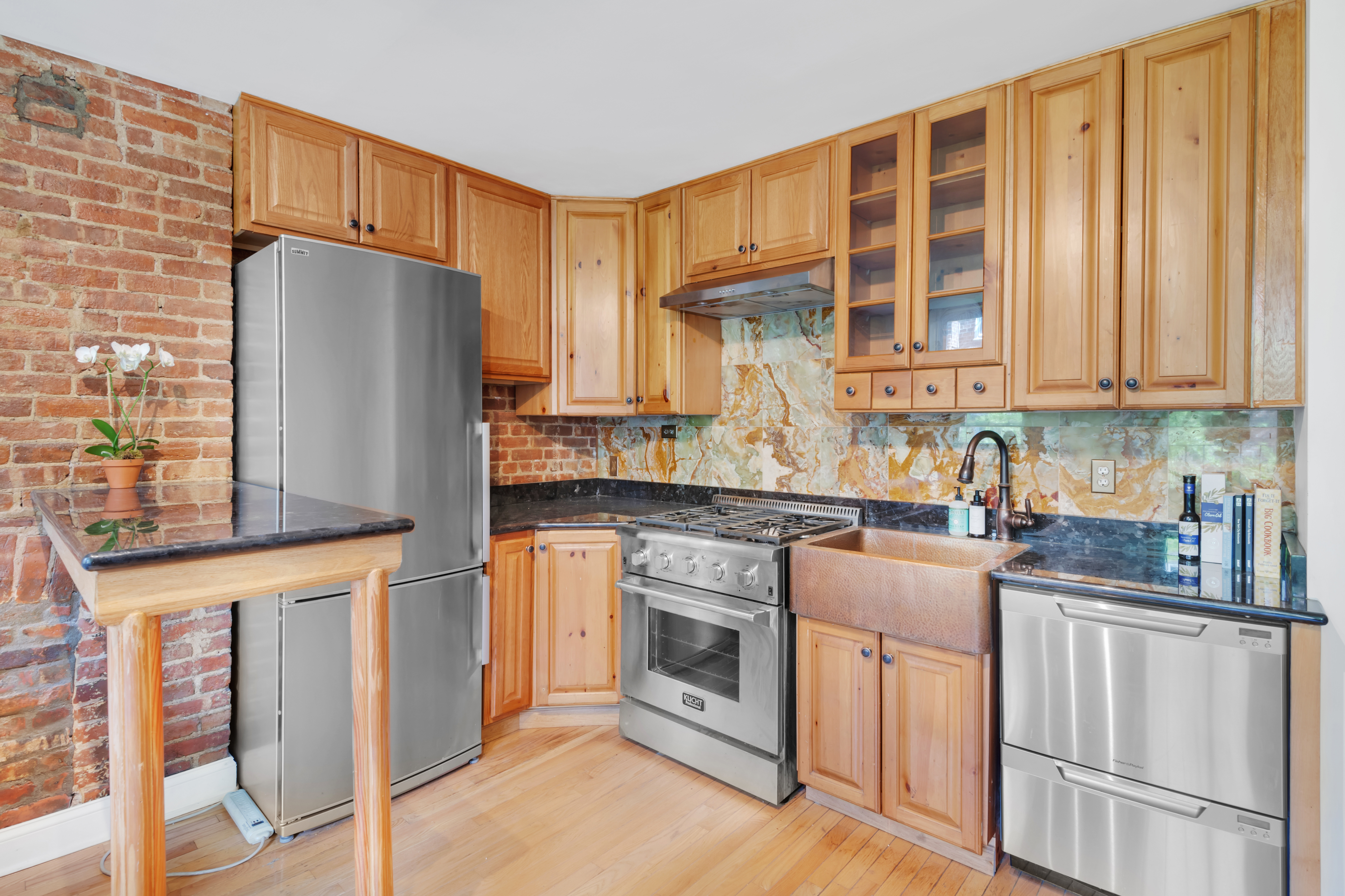 220 East 82nd Street, Unit 4RW Manhattan, NY 10028 - Photo 4 of 11 a kitchen with stainless steel appliances granite countertop a refrigerator sink and cabinets