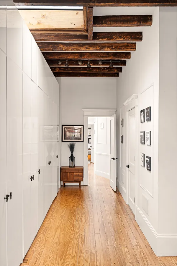 a view of hallway with wooden floor and furniture