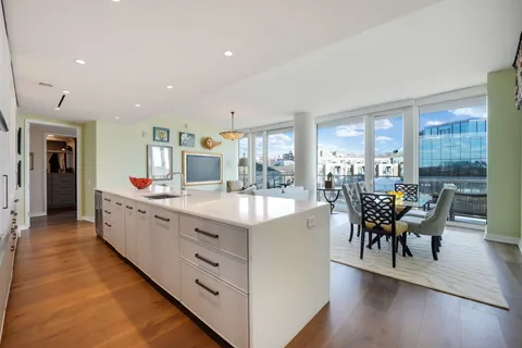a large living room with stainless steel appliances granite countertop furniture a fireplace and a large window