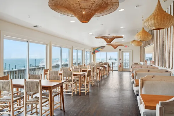 a dining room with furniture a chandelier and wooden floor