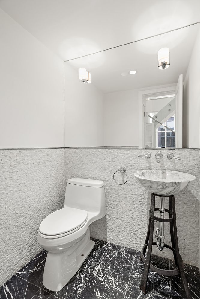 125 East 12th Street, Unit 1E Manhattan, NY 10003 - Photo 12 of 16 a bathroom with a toilet sink and mirror