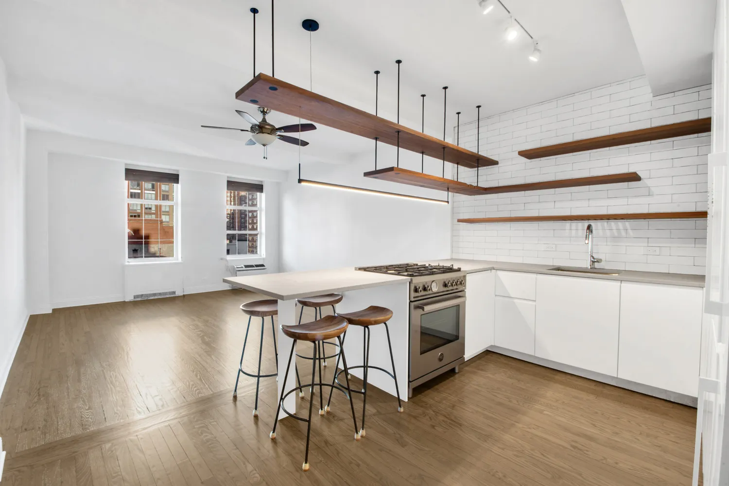 a kitchen with stainless steel appliances a stove a sink cabinets and wooden floor