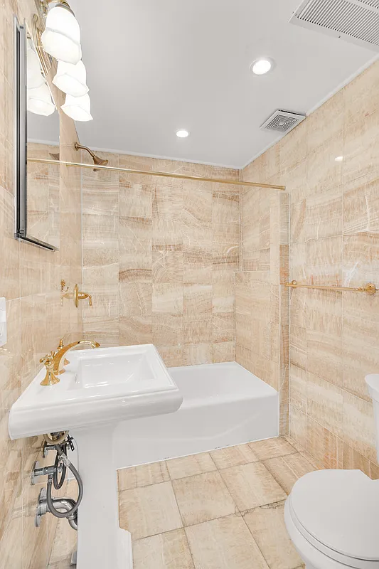 177 East 70th Street Manhattan, NY 10021 - Photo 13 of 14 a bathroom with a sink a toilet and shower