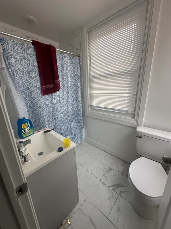 a bathroom with a sink toilet and window