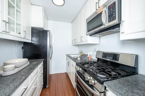 a kitchen with stainless steel appliances granite countertop a stove and a refrigerator