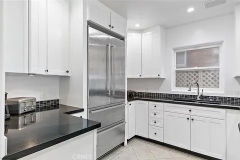 a kitchen with a refrigerator and a stove top oven