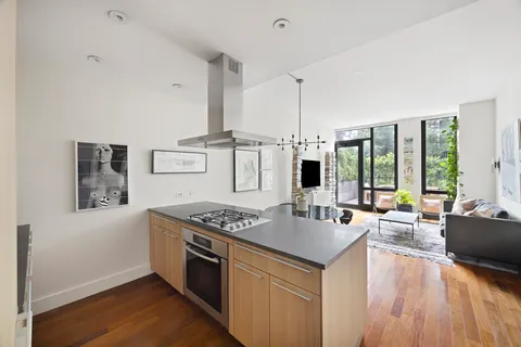 a kitchen with stainless steel appliances granite countertop a stove and a wooden floors