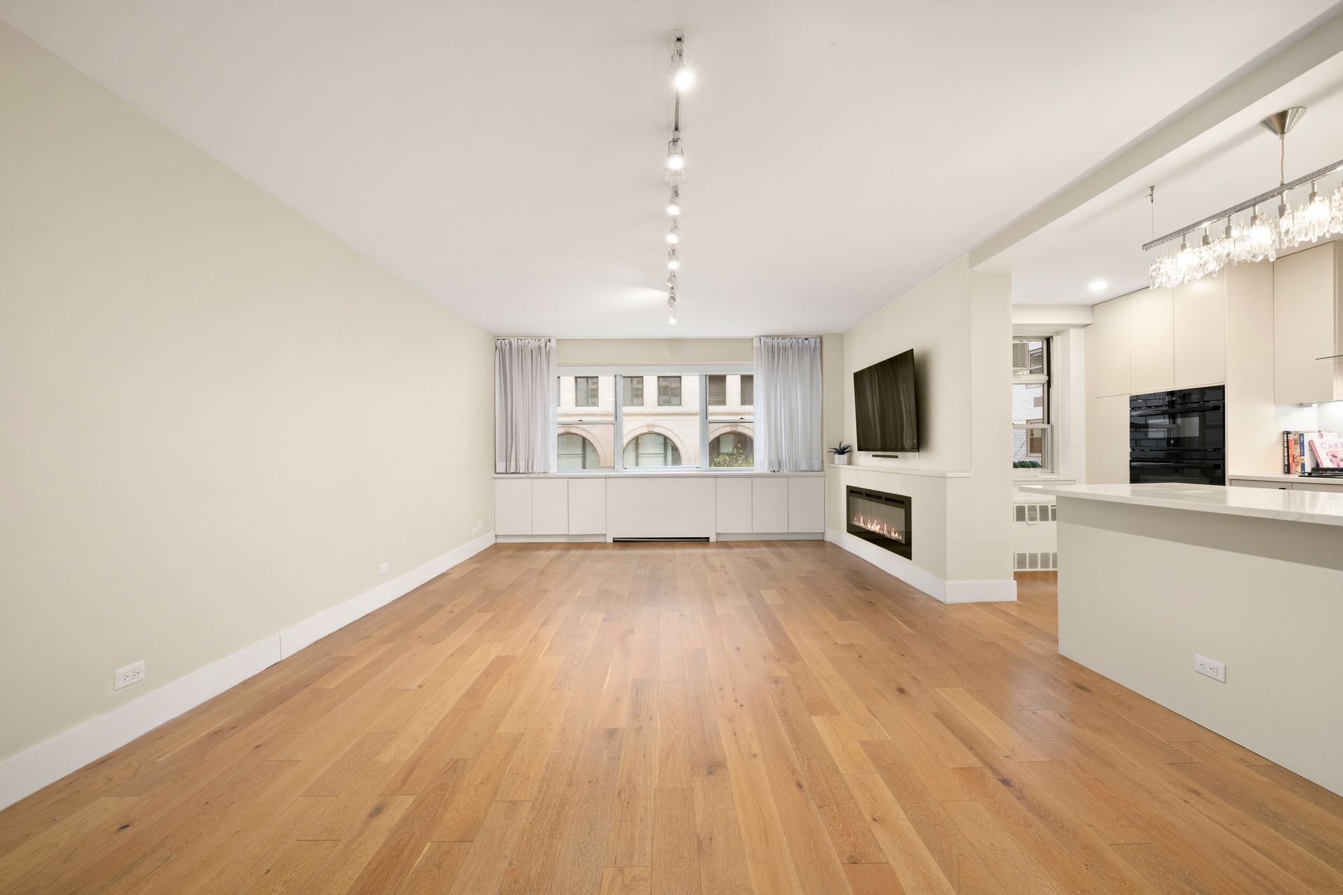 70 East 10th Street, Unit 4V Manhattan, NY 10003 - Photo 2 of 26 a view of a livingroom with wooden floor a flat screen tv and fireplace