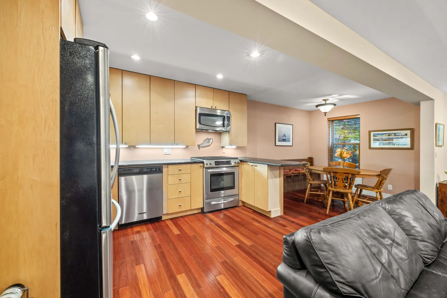 a kitchen with a sink appliances and wooden floor
