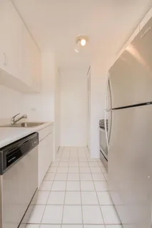 a kitchen with white cabinets and white appliances