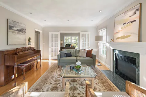 a living room with furniture a large window and a fireplace