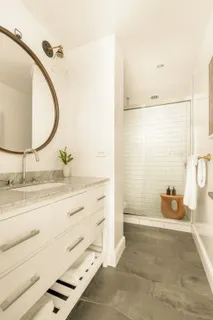 a bathroom with a granite countertop sink mirror vanity and toilet