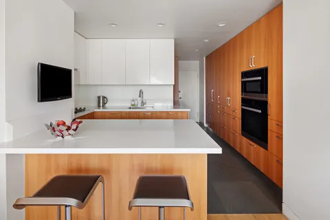 a kitchen with a sink cabinets and wooden floor