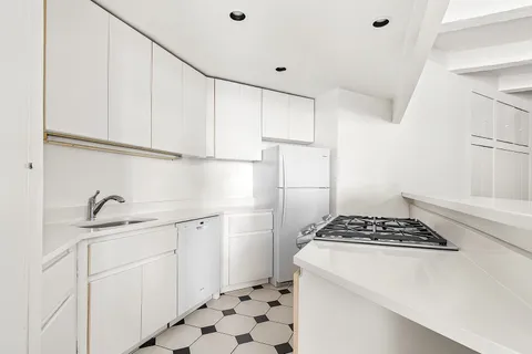 a kitchen with cabinets appliances and a window