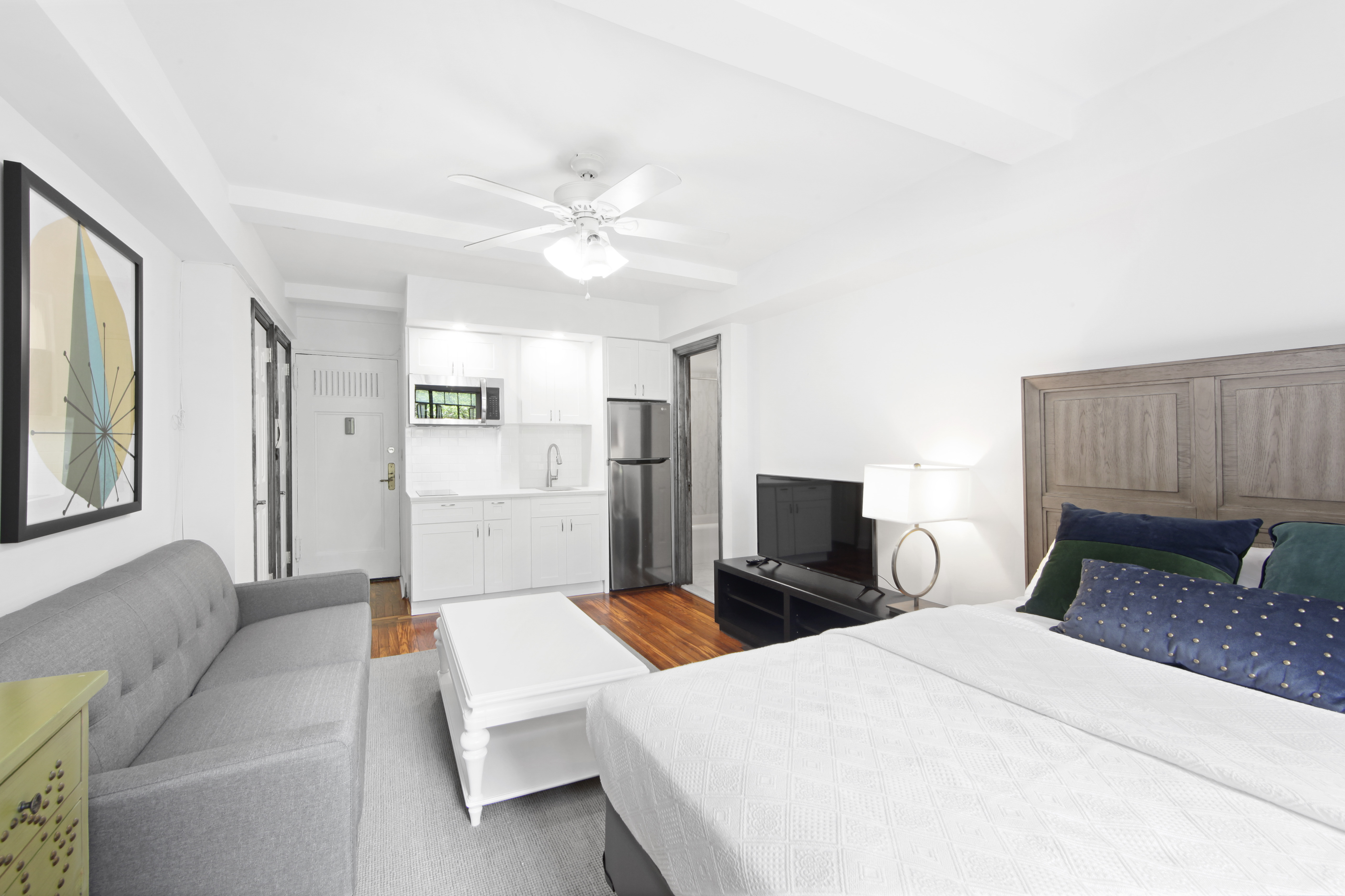 25 Tudor City Place, Unit 508 Manhattan, NY 10017 - Photo 4 of 17 a bedroom with a large bed and a chandelier