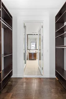 a view of a hallway with wooden floor and a cabinet