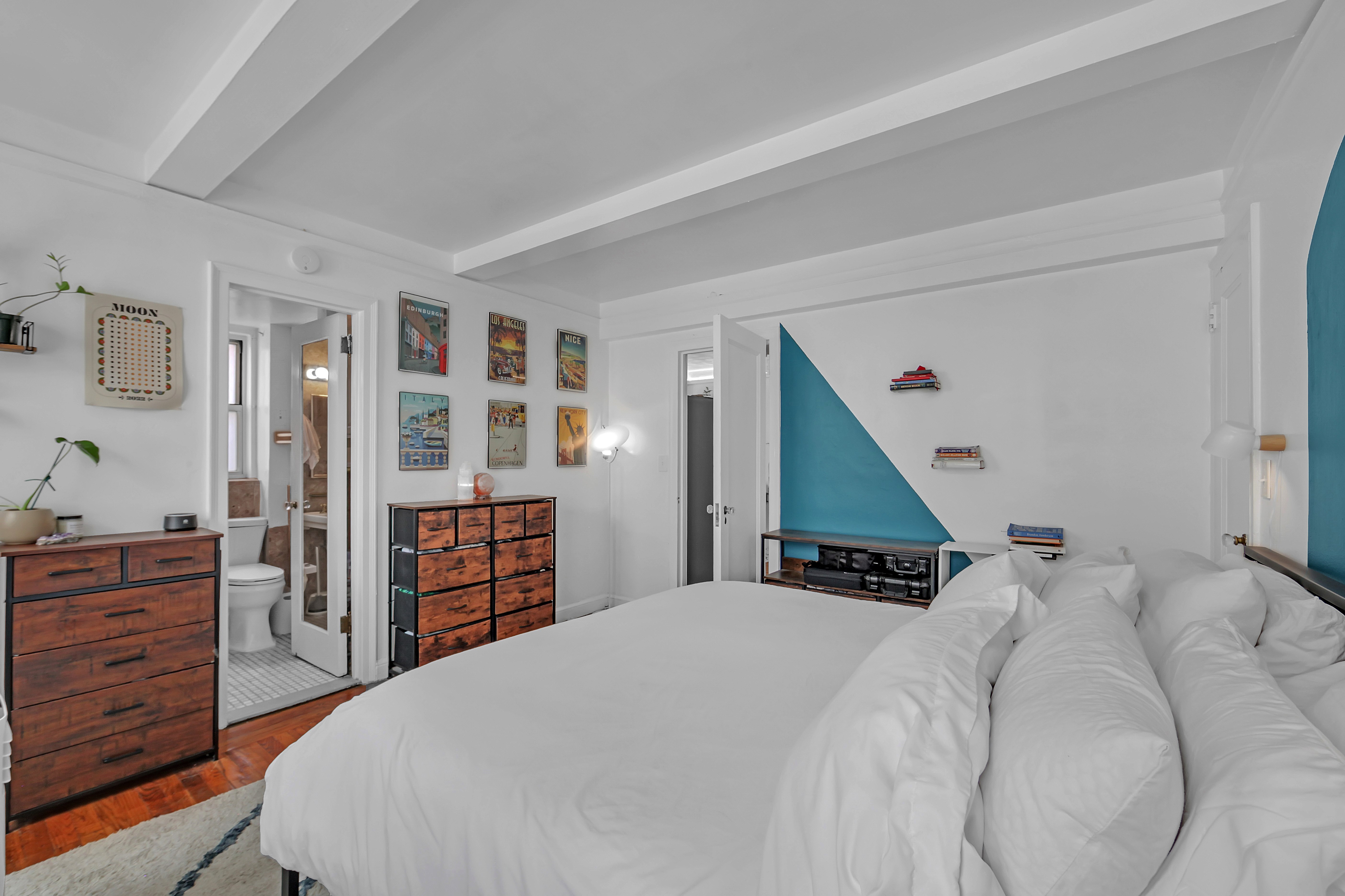 333 East 43rd Street, Unit 909 Manhattan, NY 10017 - Photo 8 of 22 a bedroom with a bed and dresser with cabinets