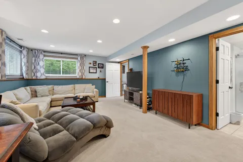 a living room with furniture a flat screen tv and a window