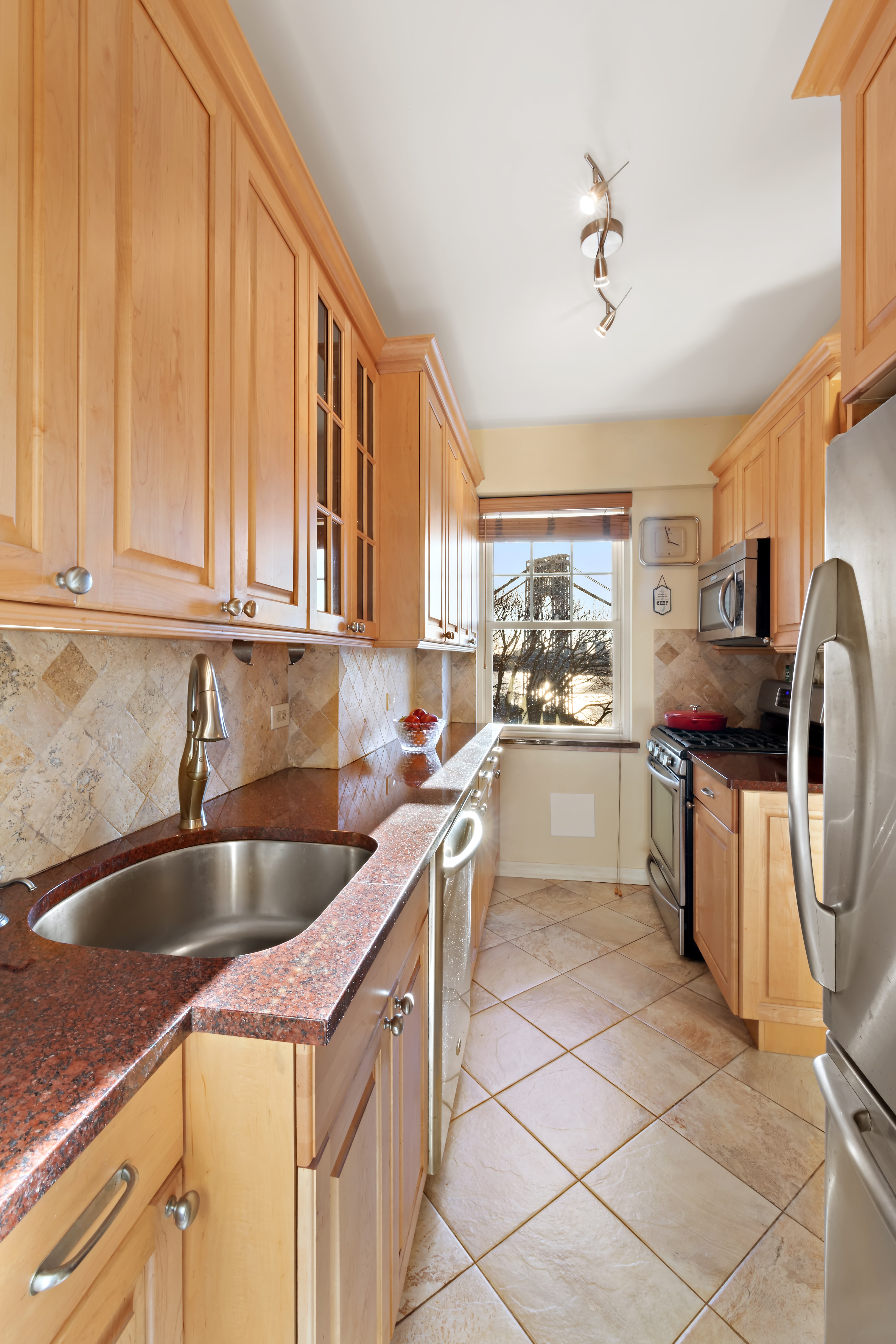 160 Cabrini Boulevard, Unit 19 Manhattan, NY 10033 - Photo 7 of 27 a kitchen with kitchen island granite countertop a sink counter top space appliances and a window