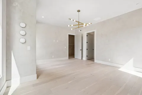 a view of an empty room with closet and wooden floor