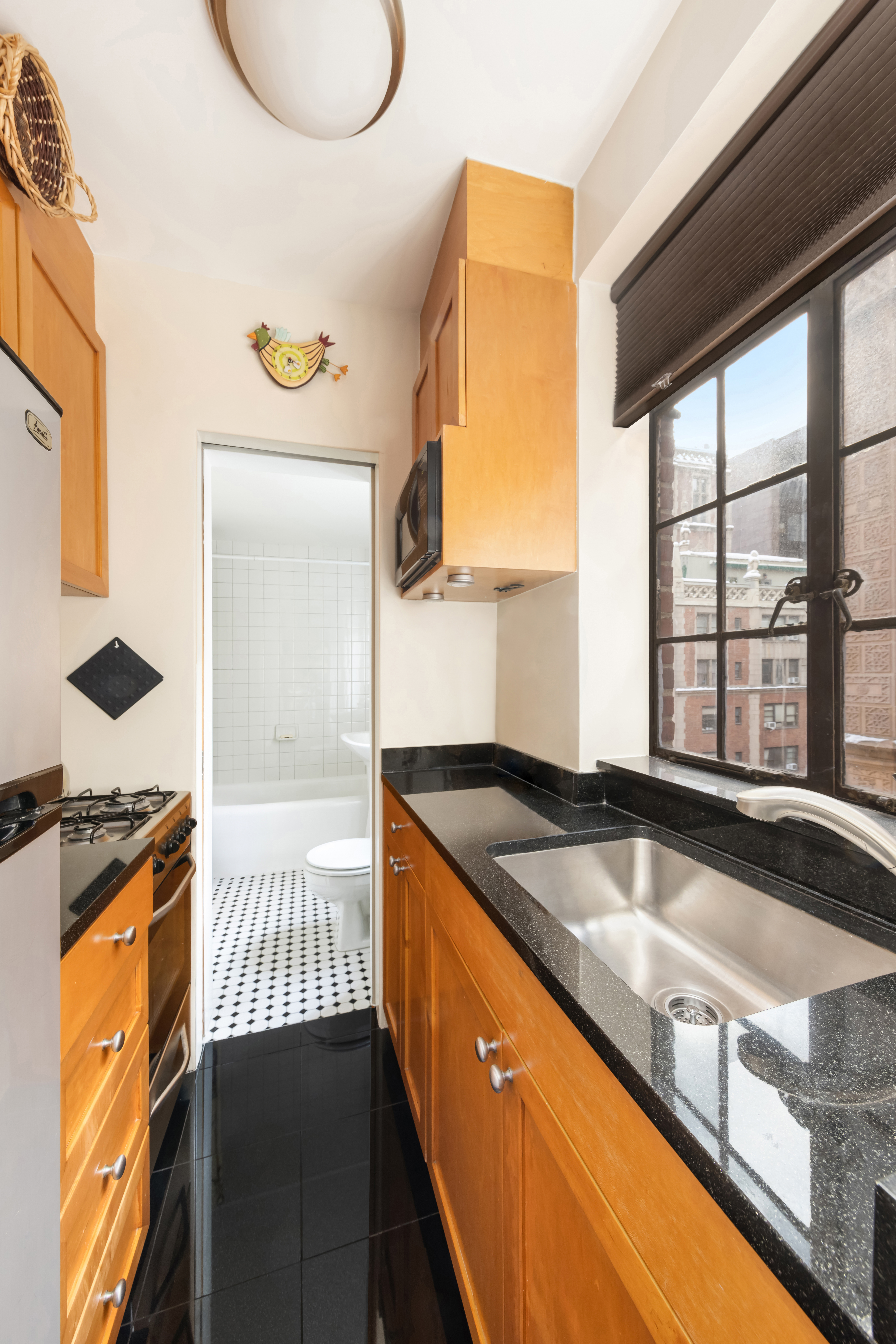 333 East 43rd Street, Unit 906 Manhattan, NY 10017 - Photo 4 of 17 a kitchen with granite countertop sink and cabinets
