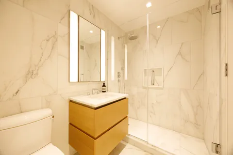 a bathroom with a sink a toilet and shower