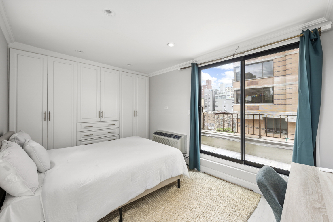 160 East 26th Street, Unit 6B Manhattan, NY 10010 - Photo 5 of 10 a bedroom with a large bed and a large window