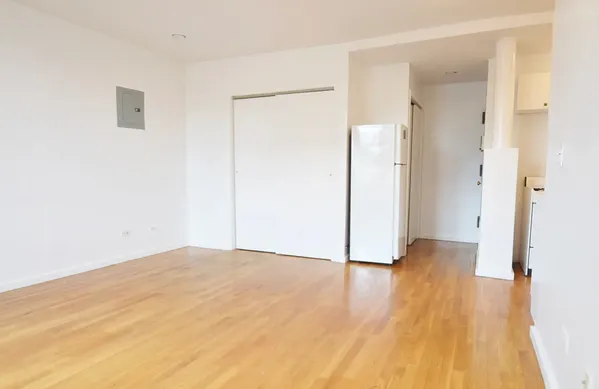 a view of an empty room with wooden floor