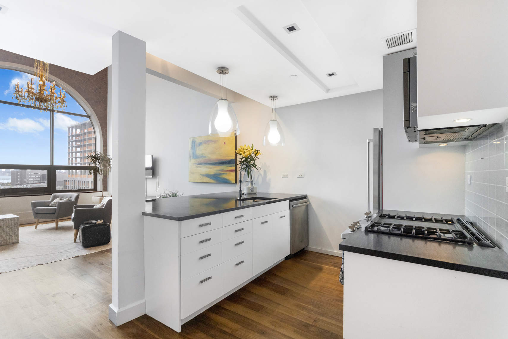 2-17 51st Avenue, Unit 606 Queens, NY 11101 - Photo 3 of 18 a kitchen with granite countertop a sink stove and cabinets