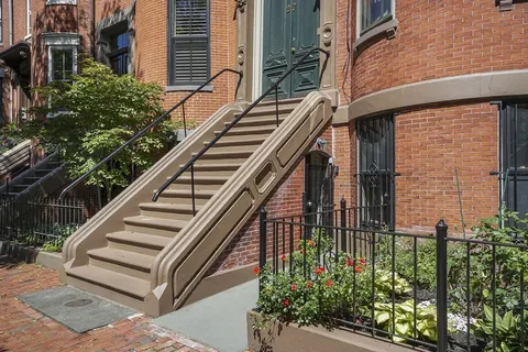 a view of a house with a wooden floor and flower plants