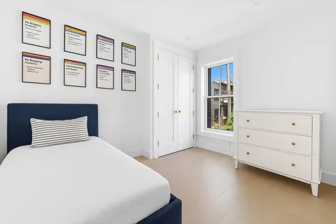 a bedroom with a bed and painting on the wall