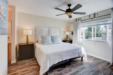 a bedroom with a bed and wooden floor