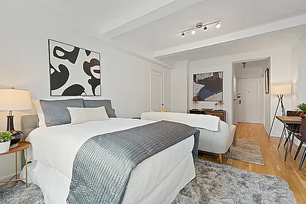 405 West 23rd Street, Unit 10D Manhattan, NY 10011 - Photo 2 of 9 a bedroom with a bed and glass table
