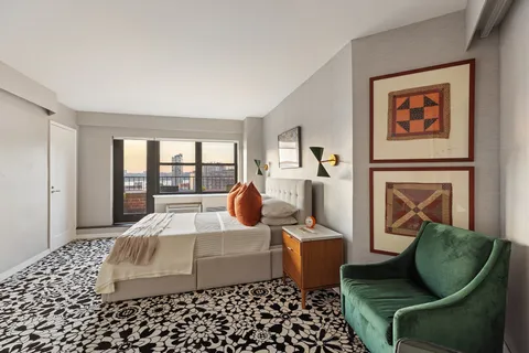 a bedroom with furniture and a large window