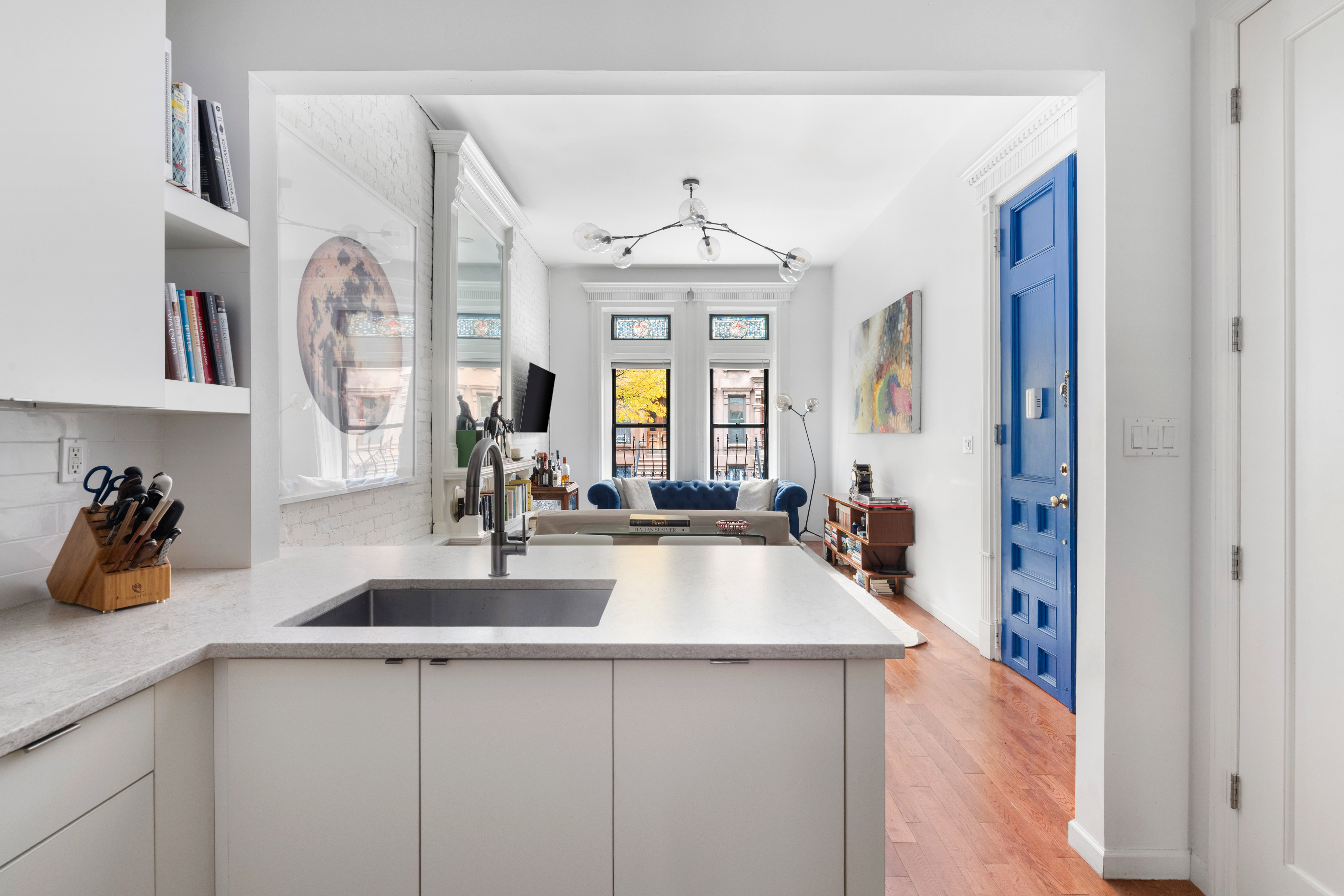 121 West 131st Street, Unit 2 Manhattan, NY 10027 - Photo 5 of 14 a view of a kitchen with a sink and a chandelier