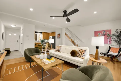 a living room with furniture and a wooden floor